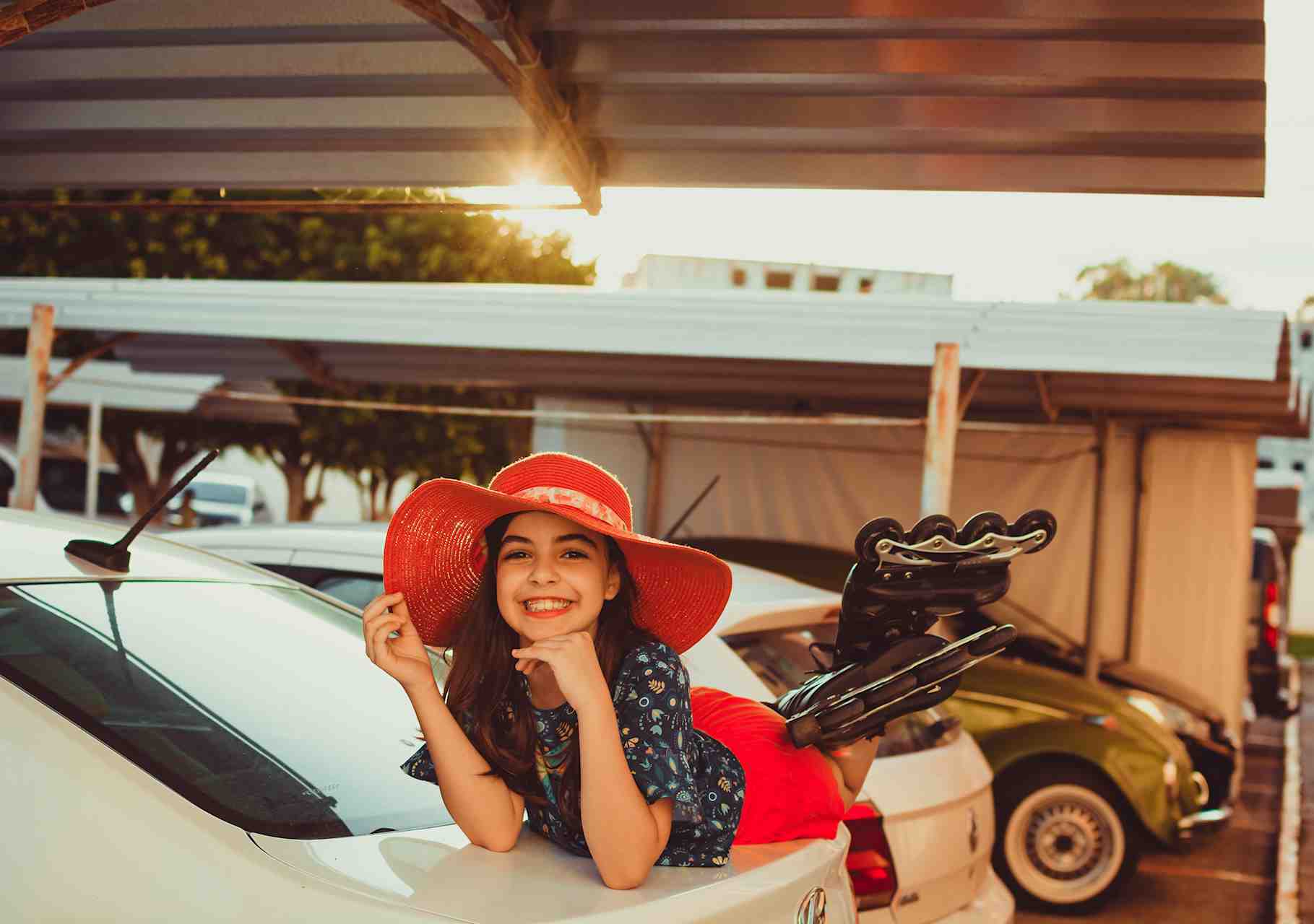 Retrato de Aline sorrindo, calçada com patins e deitada sobre um carro
